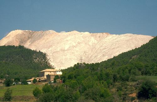 The Cogulló de Sallent salt dump seen from the south side. In the foreground you can see a farmhouse and behind it the gigantic mountain of salt, product of the mining residues from which the extraction of potassium is produced /Jordi Badia / Montsalat