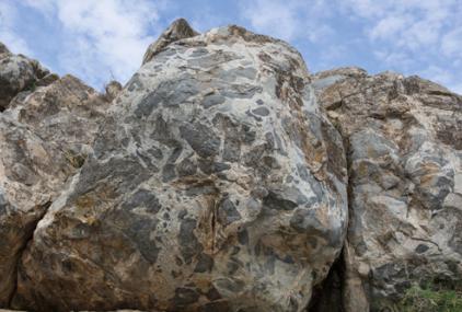 Una de las formaciones rocosas pertenecientes al afloramiento de Gerena. A la derecha, un detalle de la interacción entre dos magmas distintos.  / Daniel Gómez Frutos