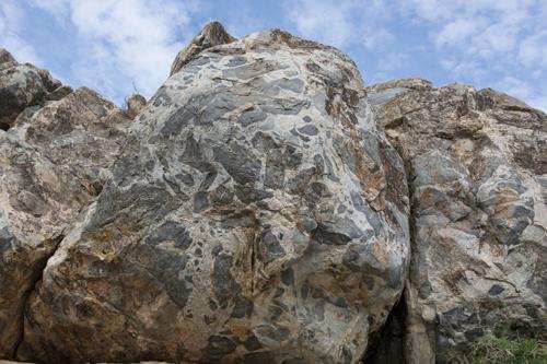 Una de las formaciones rocosas pertenecientes al afloramiento de Gerena. A la derecha, un detalle de la interacción entre dos magmas distintos.  / Daniel Gómez Frutos