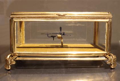 Microscopio original de Leeuwenhoek dentro de una cajita de cristal decorada con bordes dorados